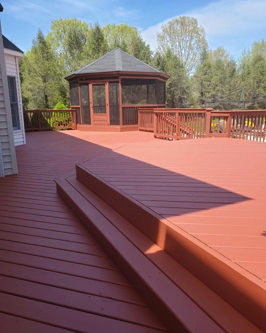 A finished backyard deck with a screened gazebo.