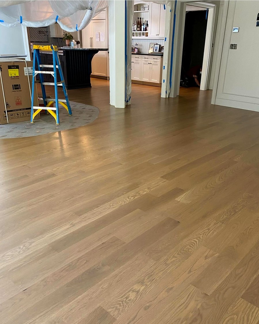 A hardwood floor mid-refinish, with surfaces masked off during the finishing process.