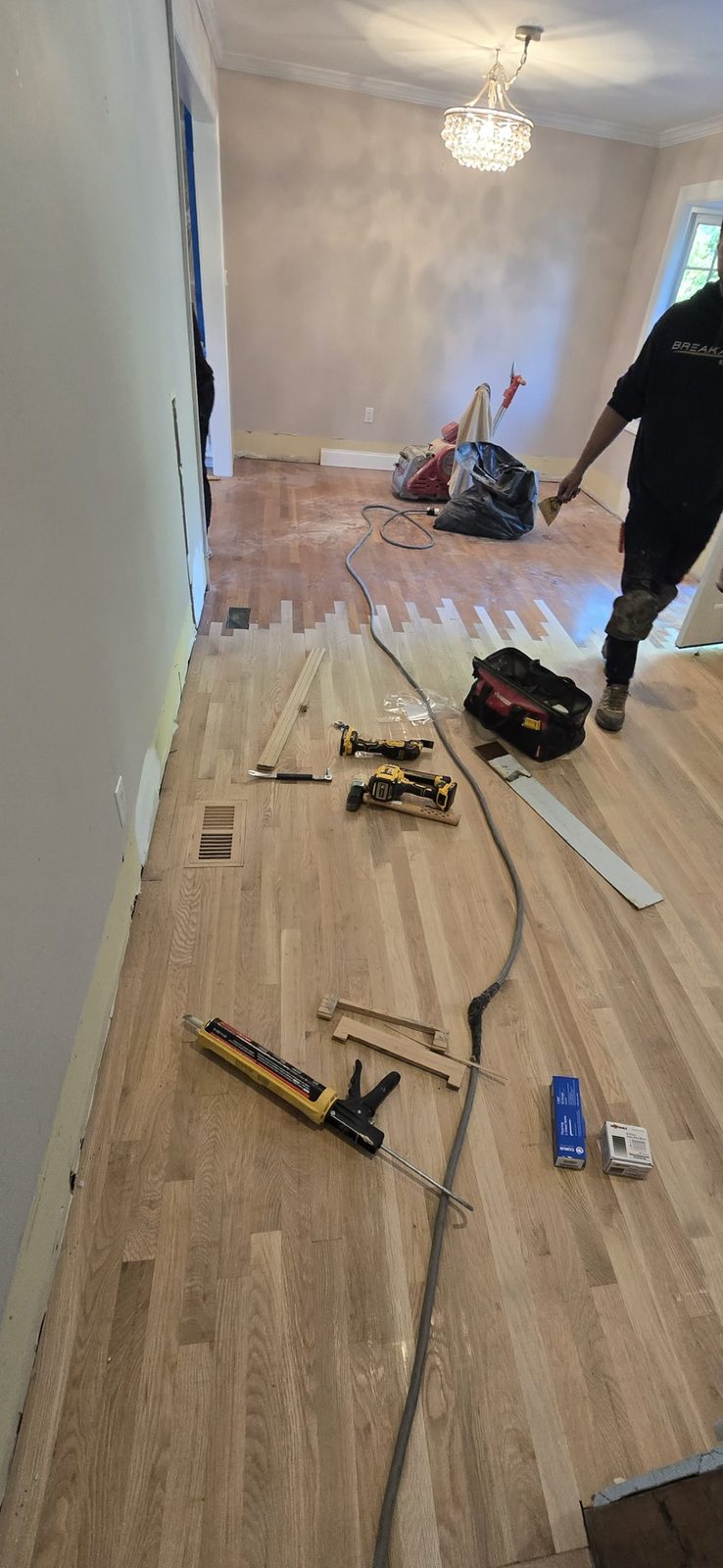 A hardwood floor being sanded and prepped ahead of refinishing.