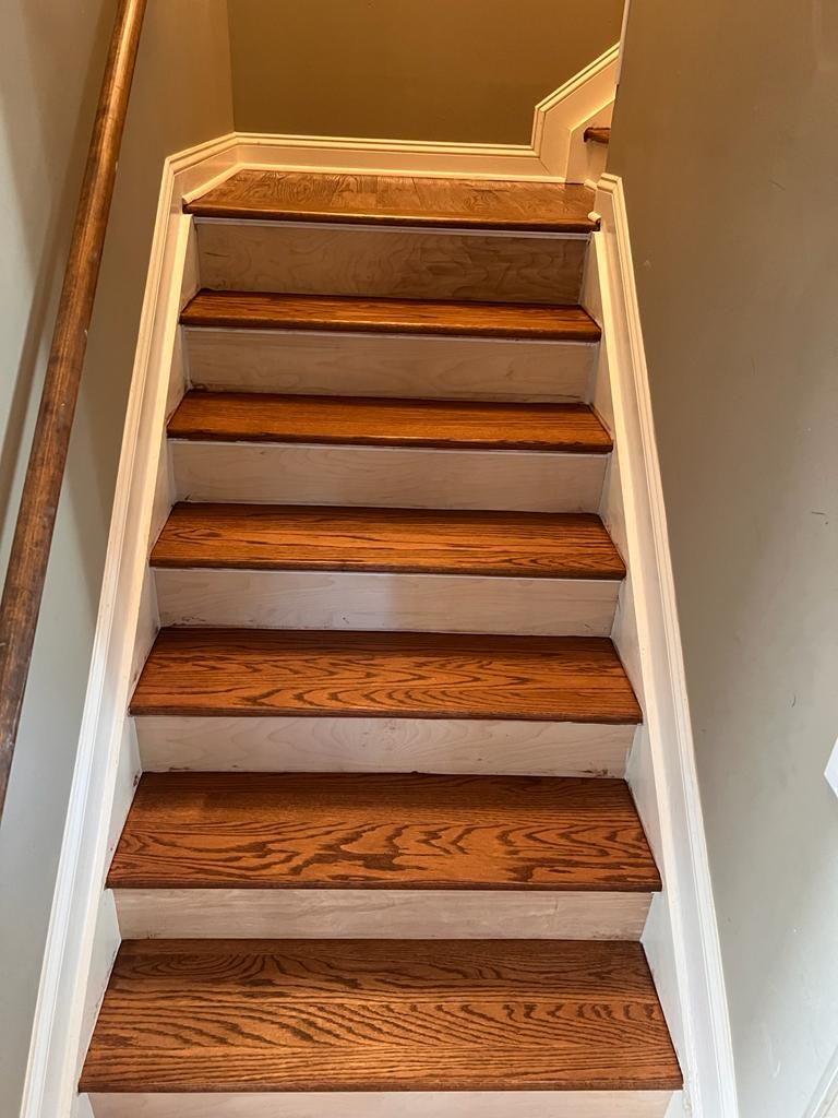 A staircase finished with rich mahogany-stained treads and white risers.