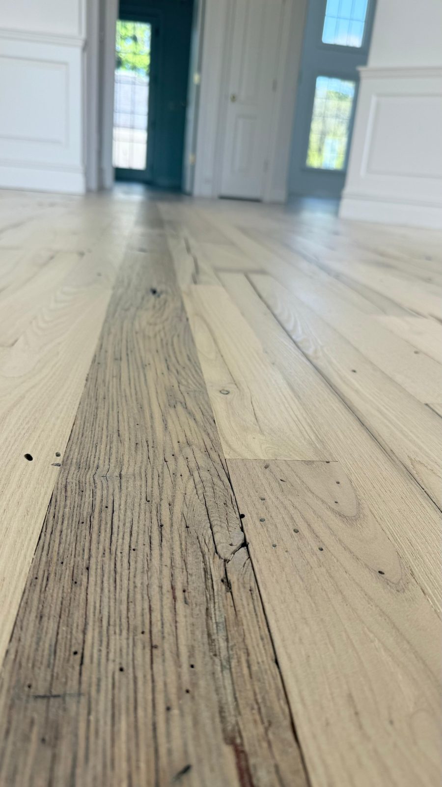 A close-up of rustic wide-plank flooring with natural character and grain.