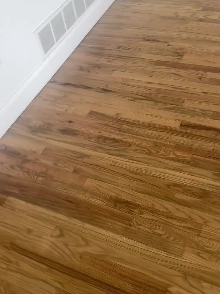 A close pass across a newly refinished hardwood floor.