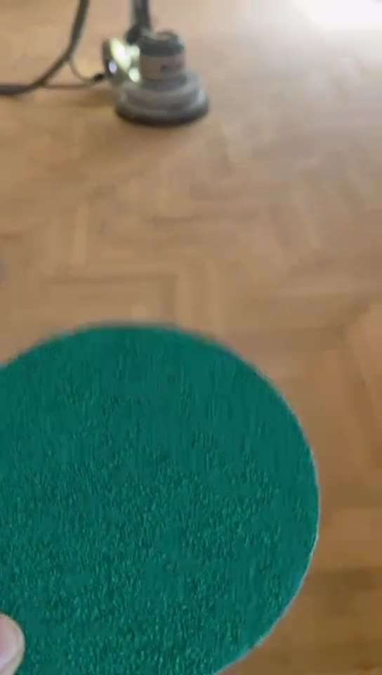 Prepping a sanding disc for an edge sander on a herringbone floor.