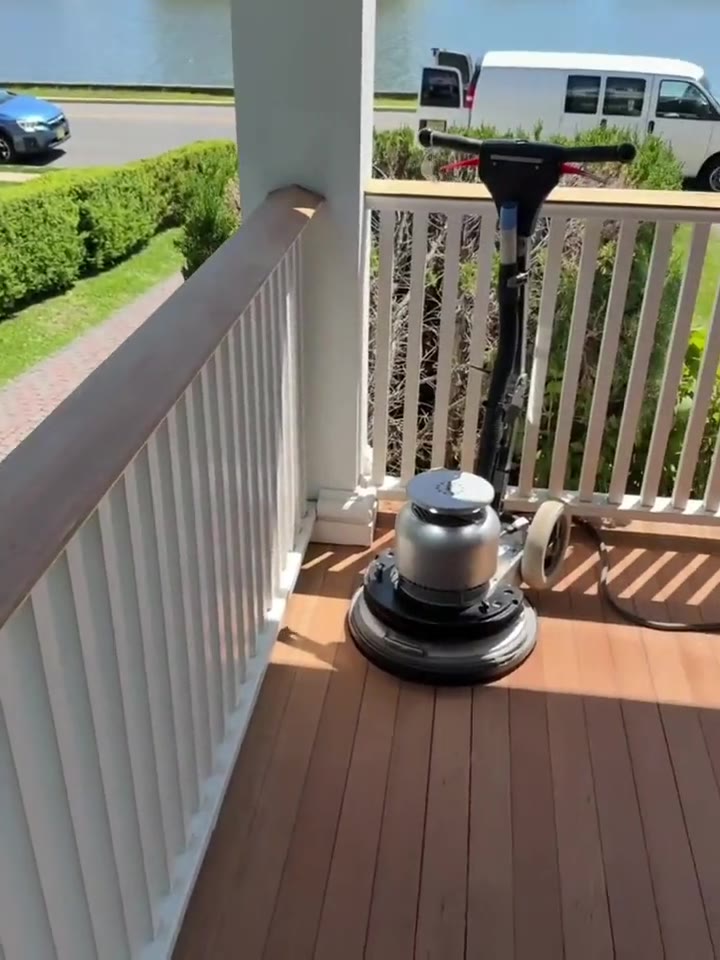 A floor sander set up on an exterior deck, ready for refinishing.