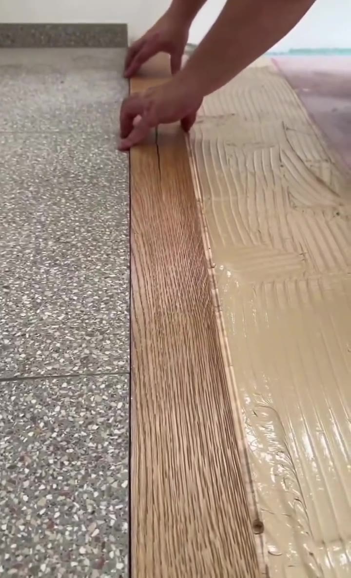 Fitting a hardwood plank against an existing tile floor at a doorway transition.