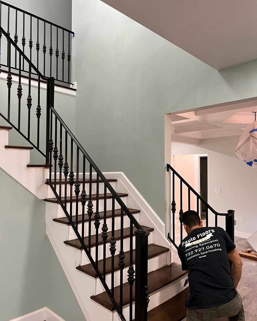 A staircase with custom iron railing, finished to match the surrounding hardwood.